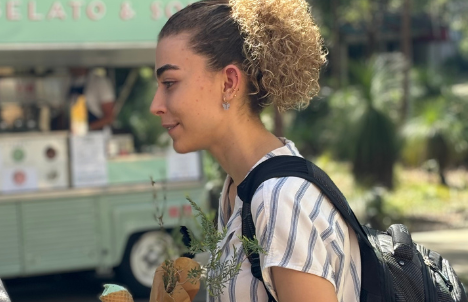 student holding a plant and an ice cream